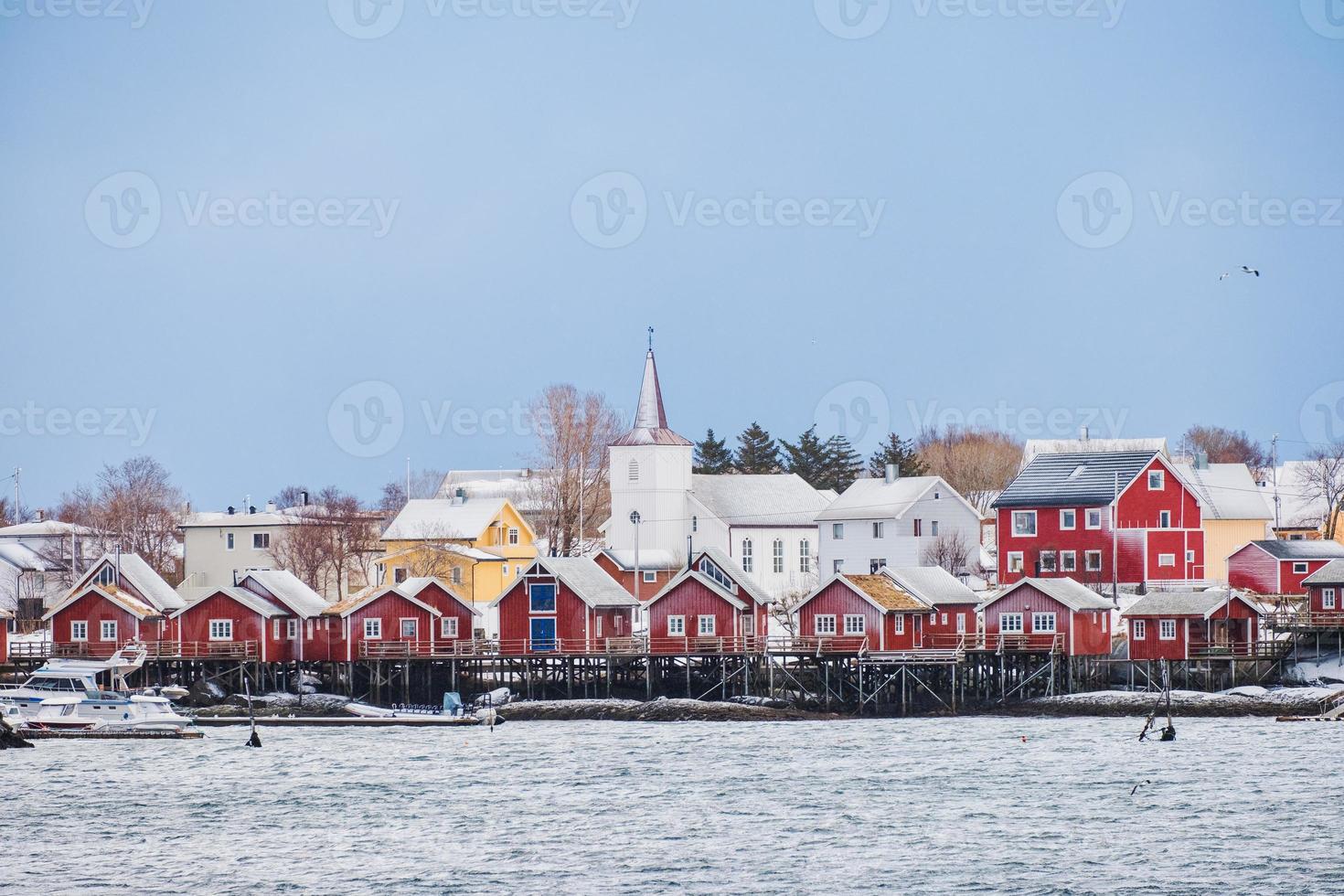 pueblo pesquero con iglesia cristiana en la ciudad de reine en la costa en un día de nieve en las islas lofoten foto