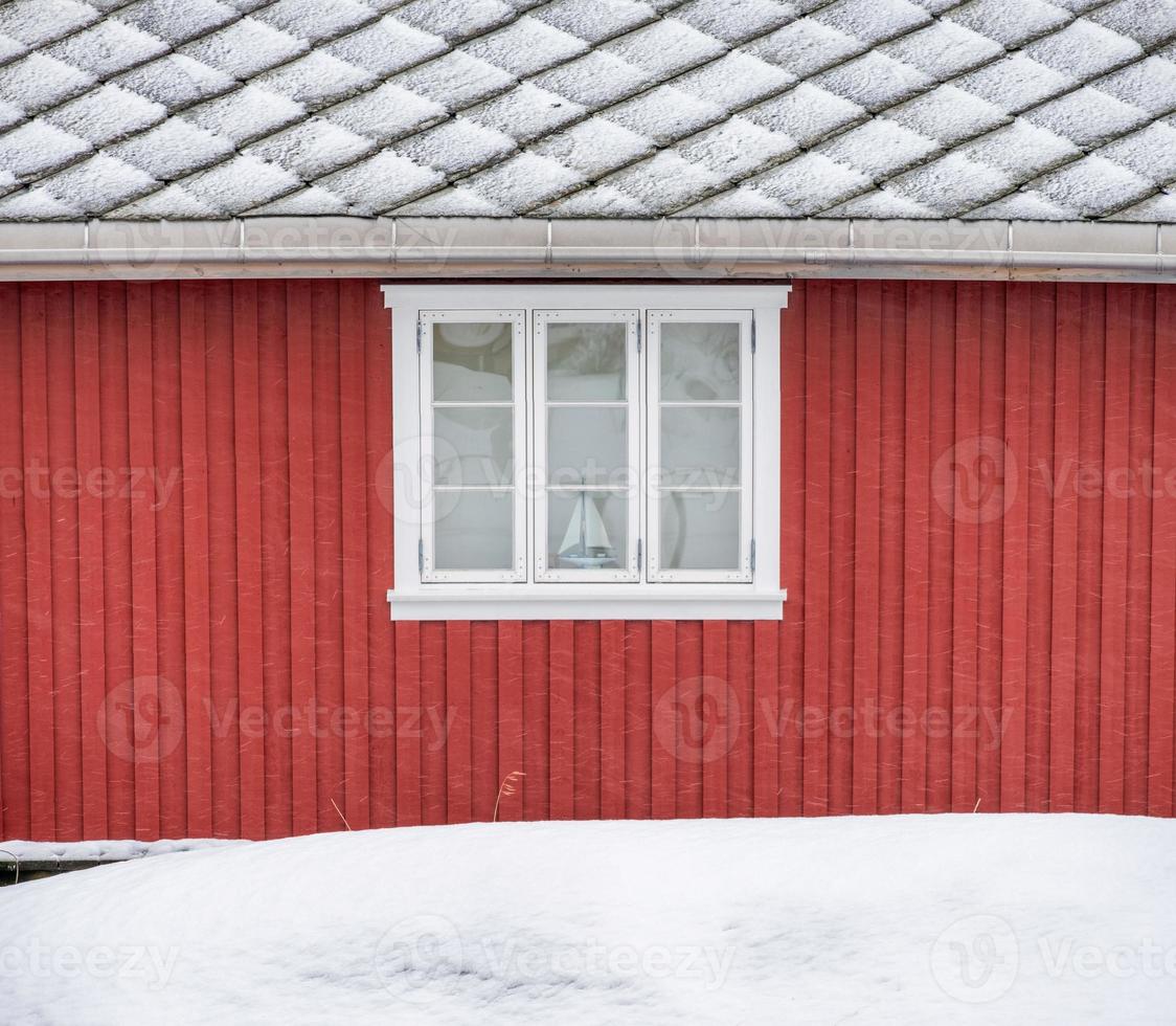 pared exterior de madera roja con ventana y techo foto