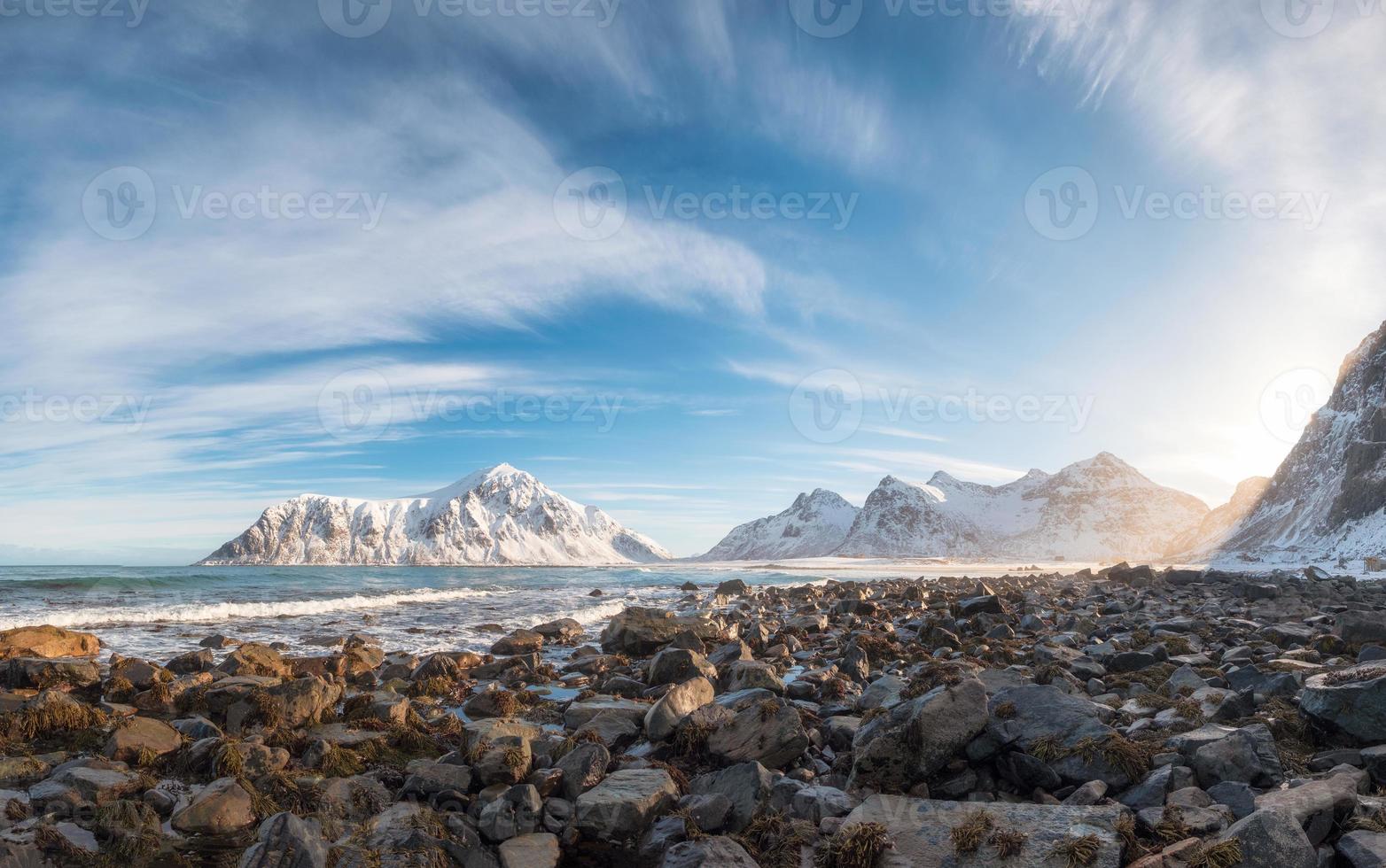 Panorama of snow mountain range with rocks in arctic ocean on winter photo