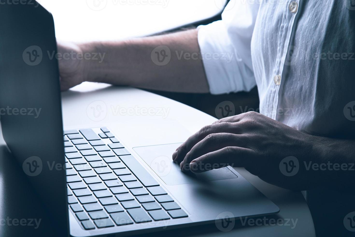 hombre de negocios anónimo ve las manos, usa su computadora portátil mystert y el concepto de tecnología moderna. foto