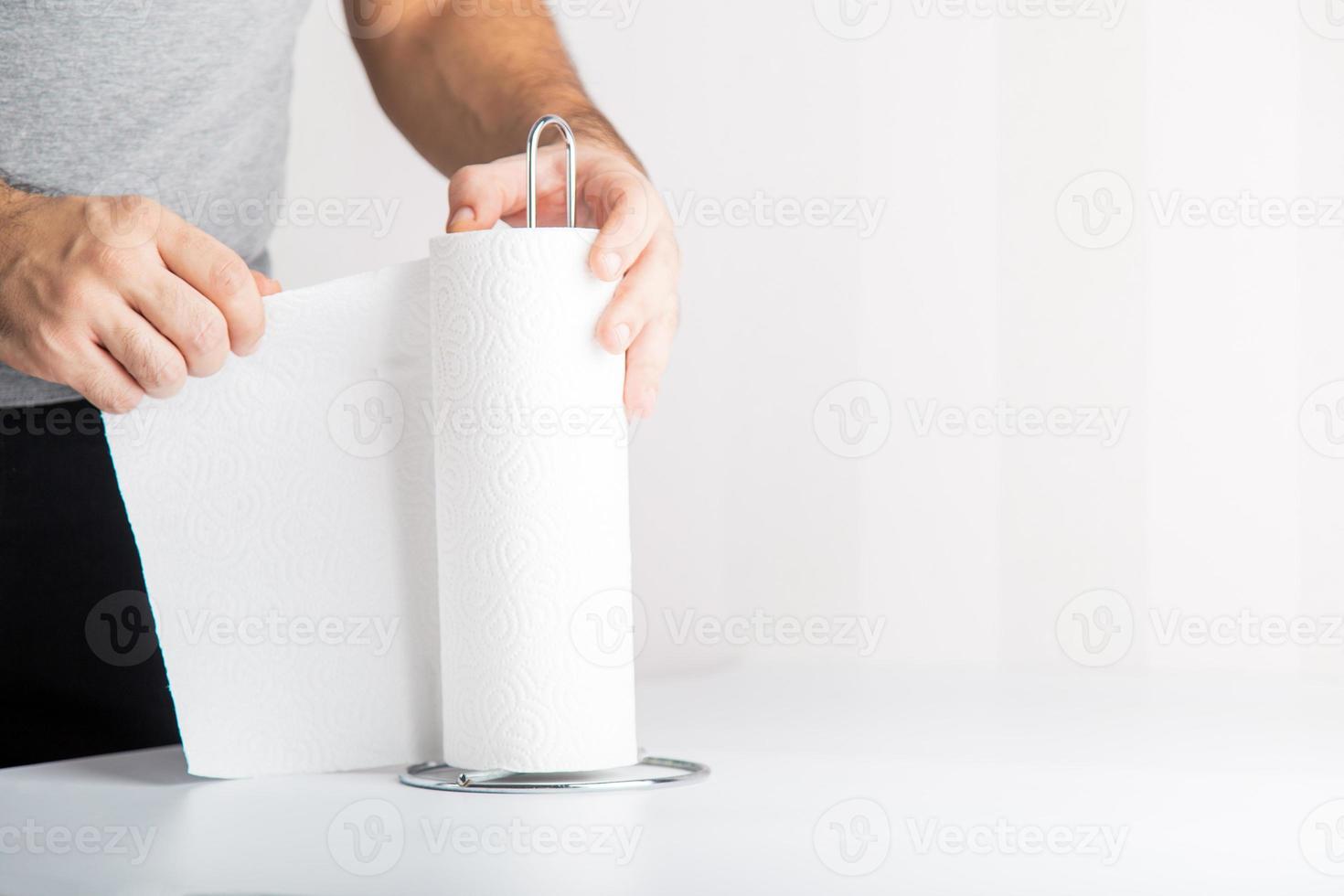 an anonymous hand is tearing off paper towel, hygiene concept copy space includes. photo