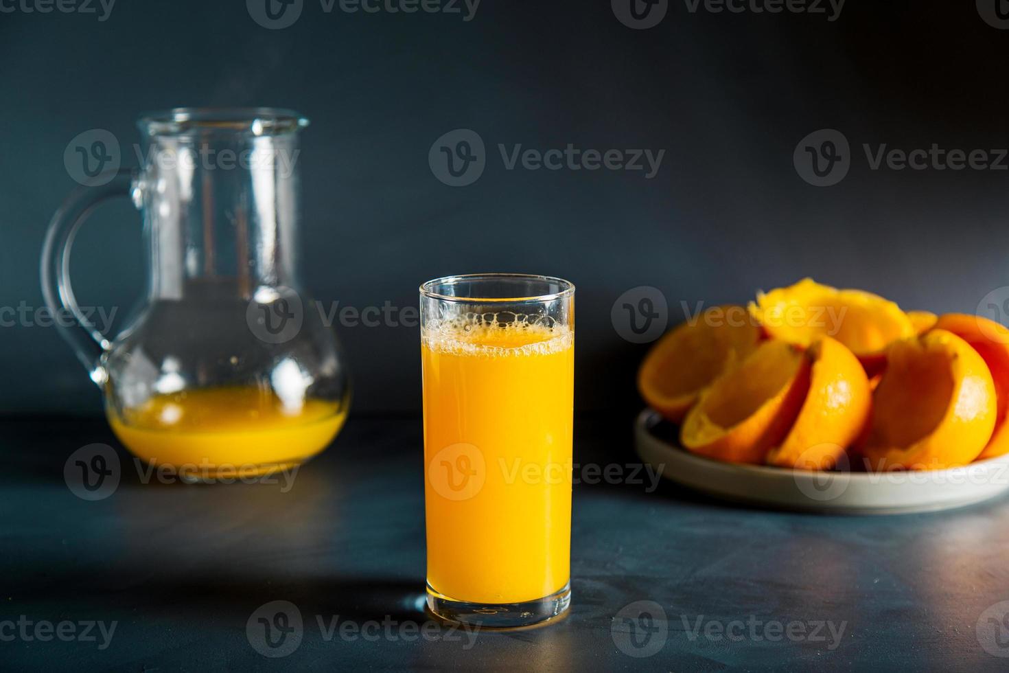 Dark moody orange juice squuze concept in studio. Includes copy space. photo