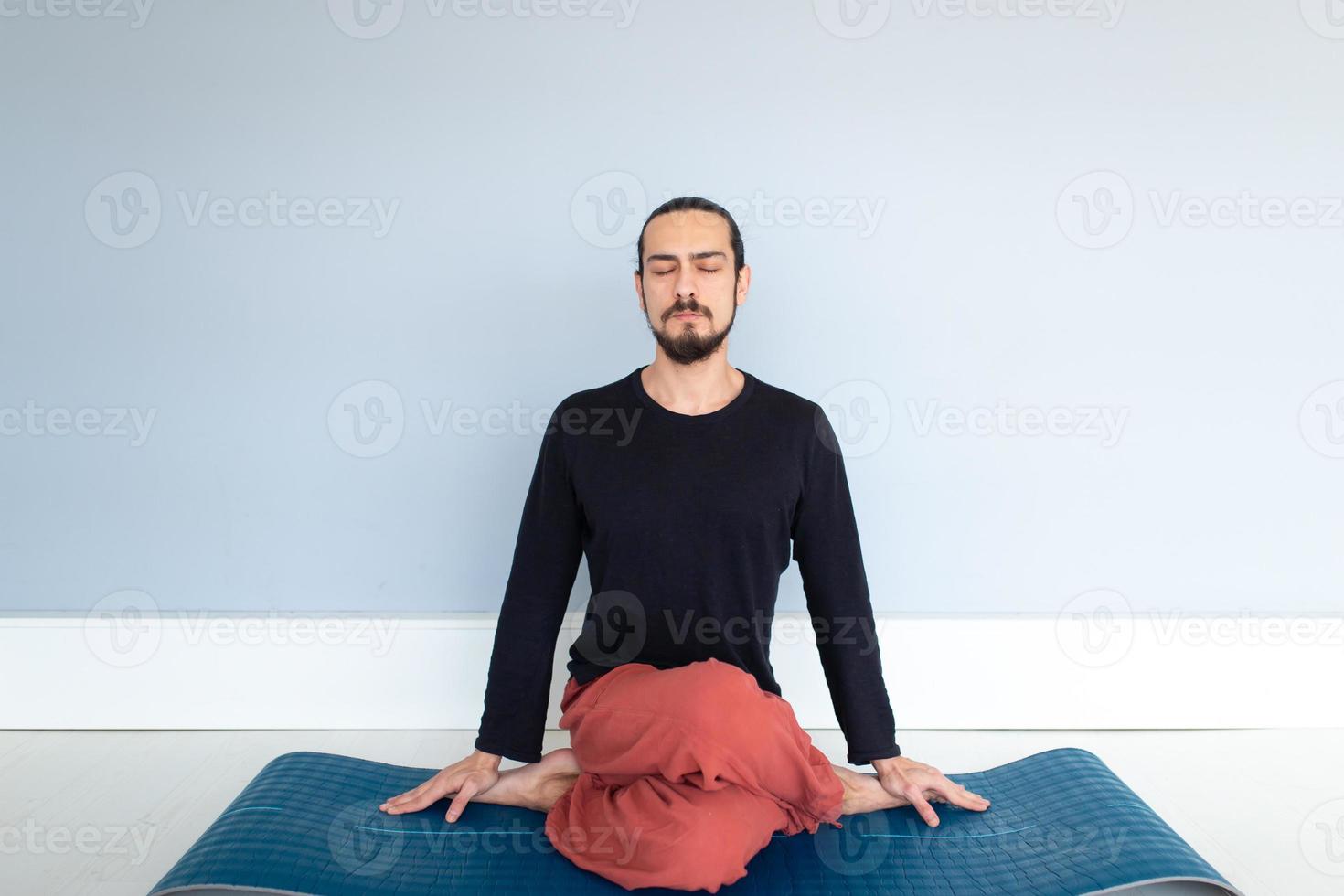 Man in peace with calm mood in meditation trance. Includes copy space, interior shot with professional performer. photo