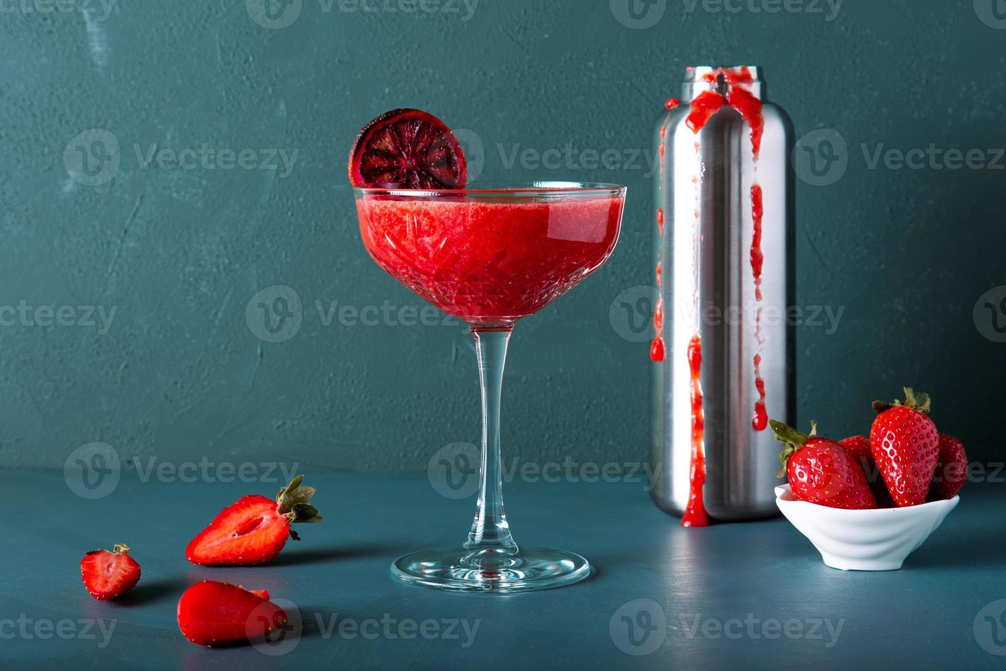 vista de detalle de primer plano de cóctel o jugo de fresa con elegante taza y frutas maduras. foto