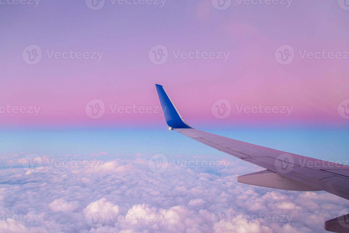 Airplane wing view during sunset with fantastic purple colors. photo