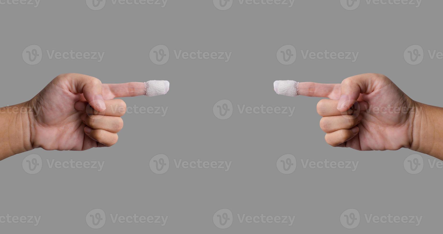 Two fingers pointing a wounded finger was treated with gauze attached To clean and prevent infection of the wound. Isolated image with gray background. Put clipping paths, copy space ready to use. photo