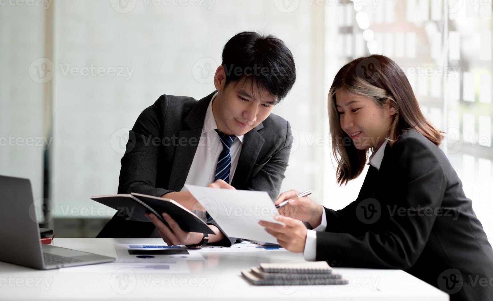 dos mujeres de negocios y hombres de negocios asiáticos trabajan juntos para hacer el trabajo en la oficina. foto