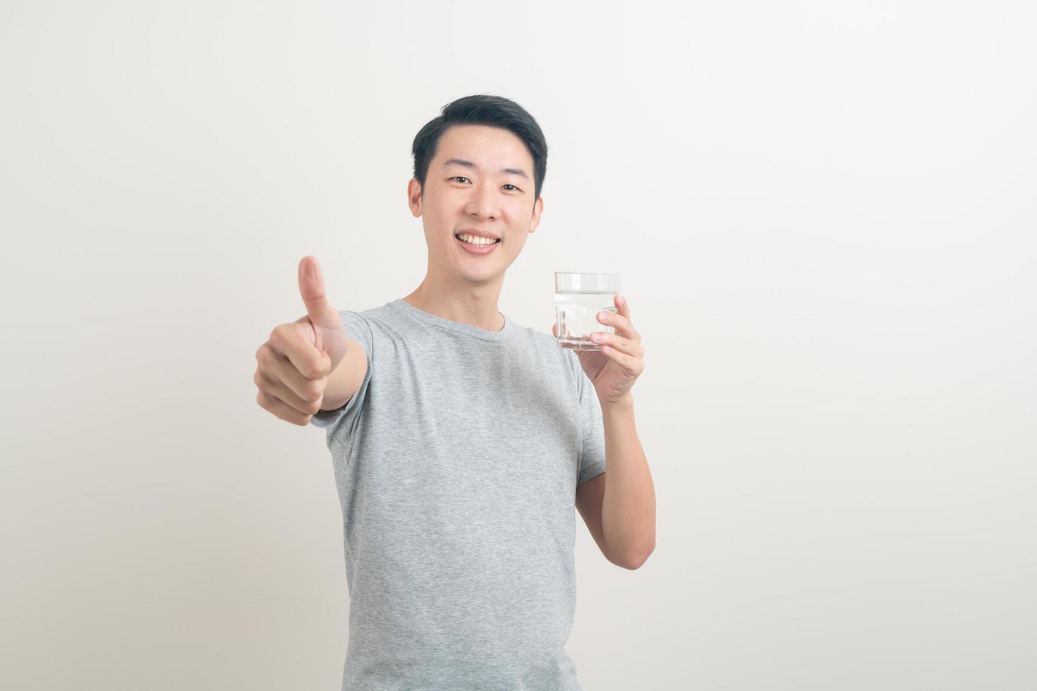 young Asian man with glass of water on hand photo