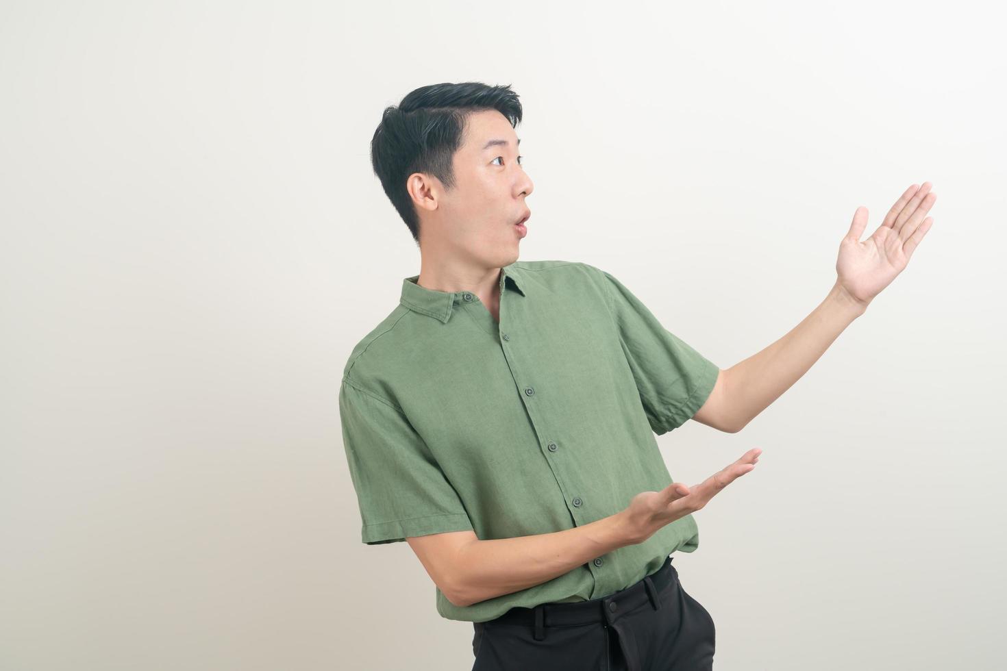 Hombre asiático con la mano apuntando o presentando sobre fondo blanco. foto