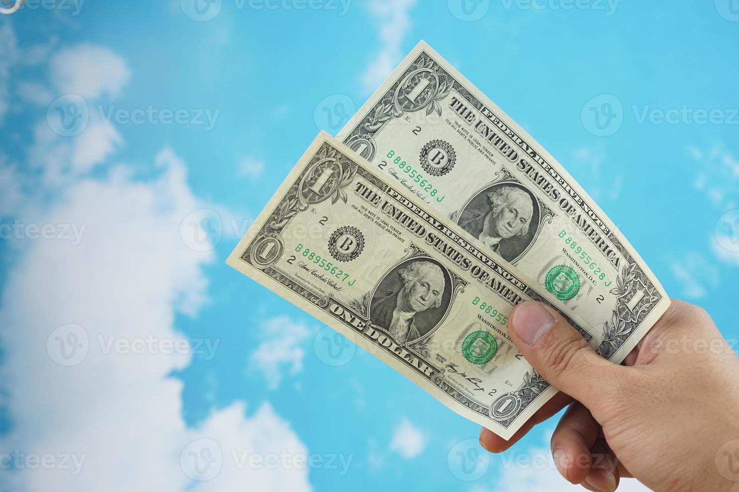 male hand with dollar isolated on sky background photo