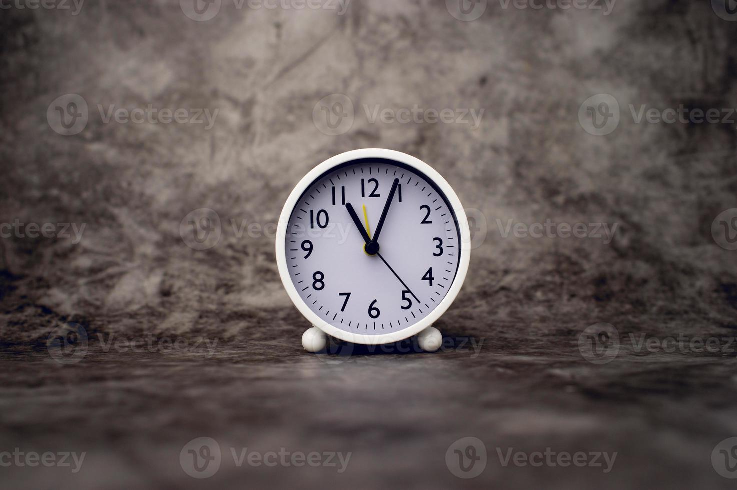 white alarm clock on marble background Time concept and setting an alarm photo