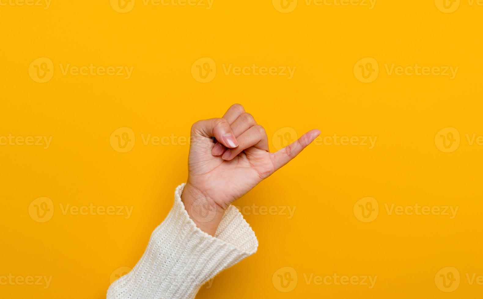 The promise of a white Asian woman's hand little finger split on yellow background gestures of commitment and reconciliation photo