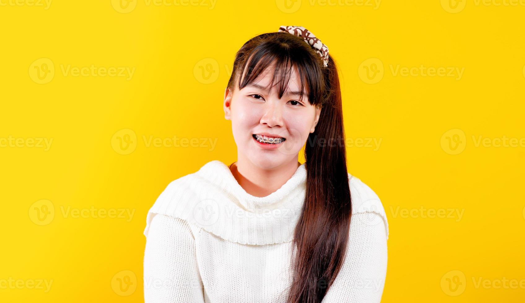 asian girl That cheerful, fun, bright smile. expression of loving eyes good living and happiness at work, relaxation, against a yellow background photo