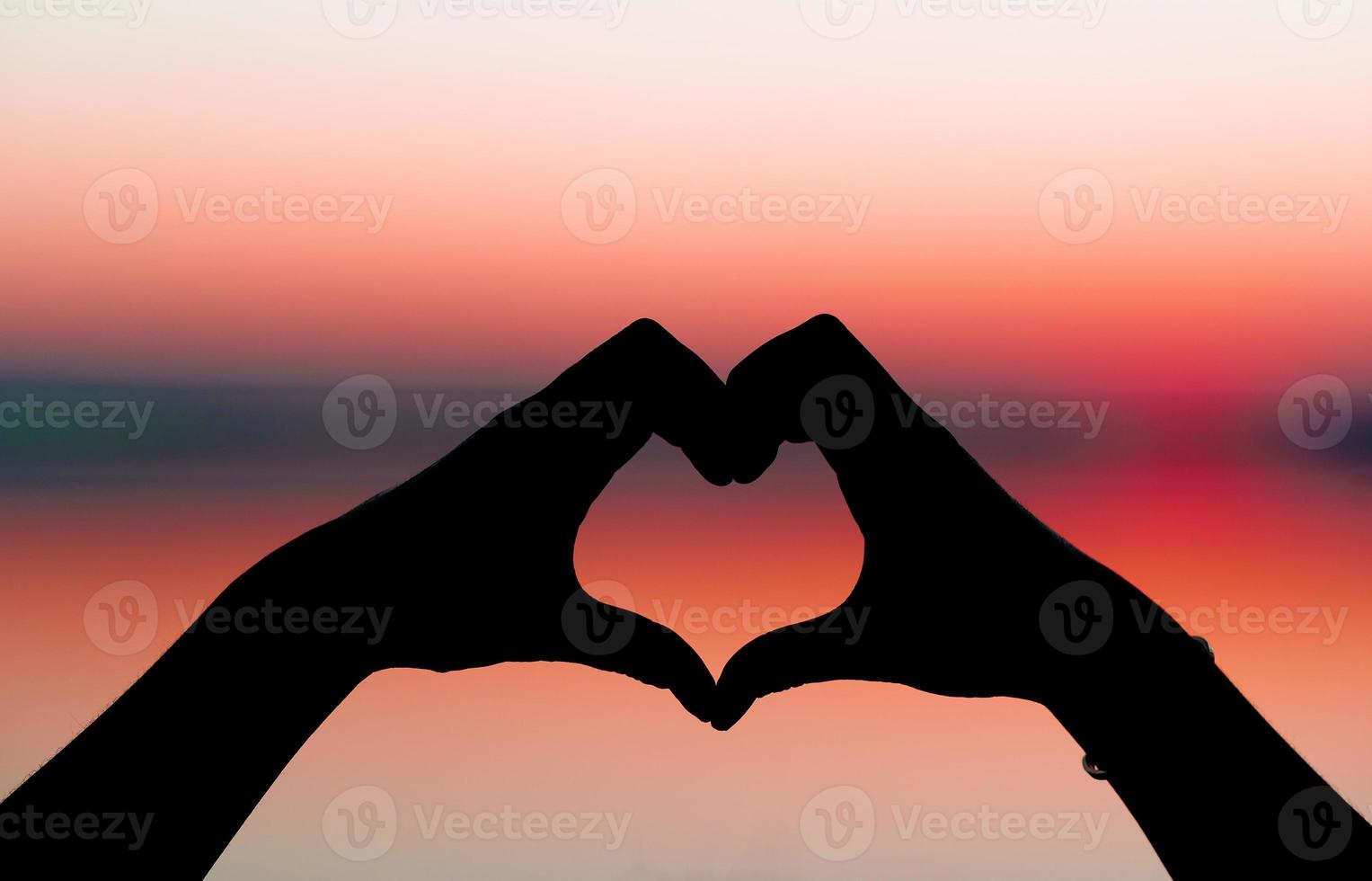 woman's hand and heart shape silhouette The heart shape on the hand represents love and affection. on the day of love Expression of love Valentine's Day photo