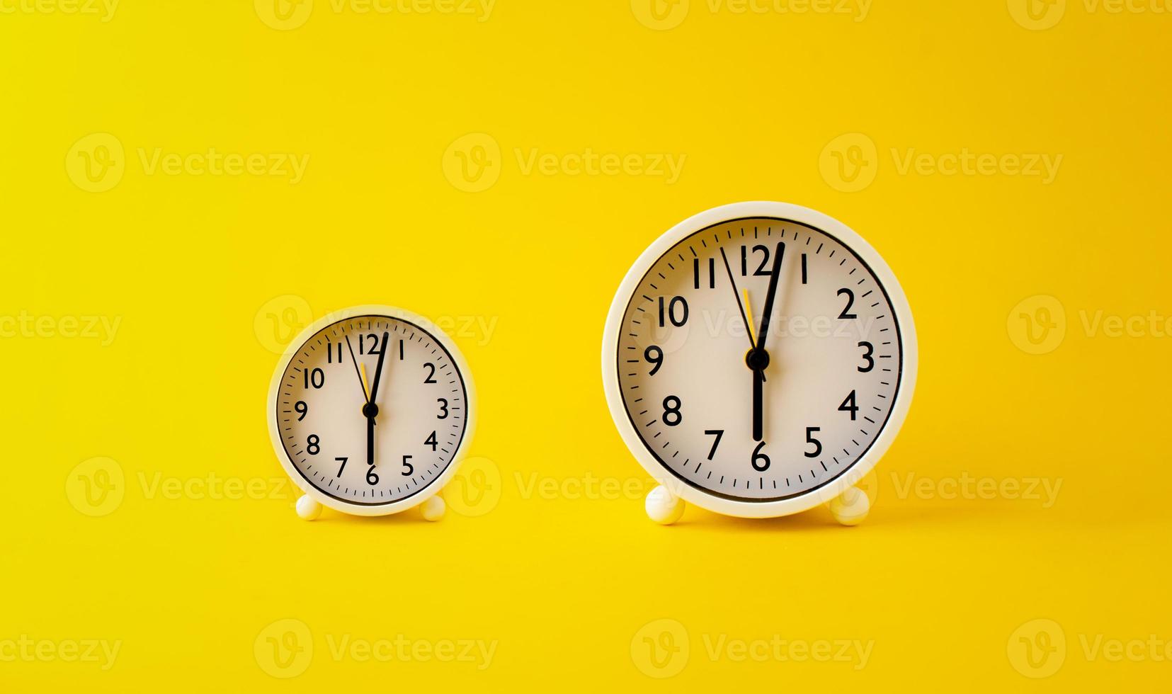 concept of time two white watches placed on a yellow background rotation of time photo