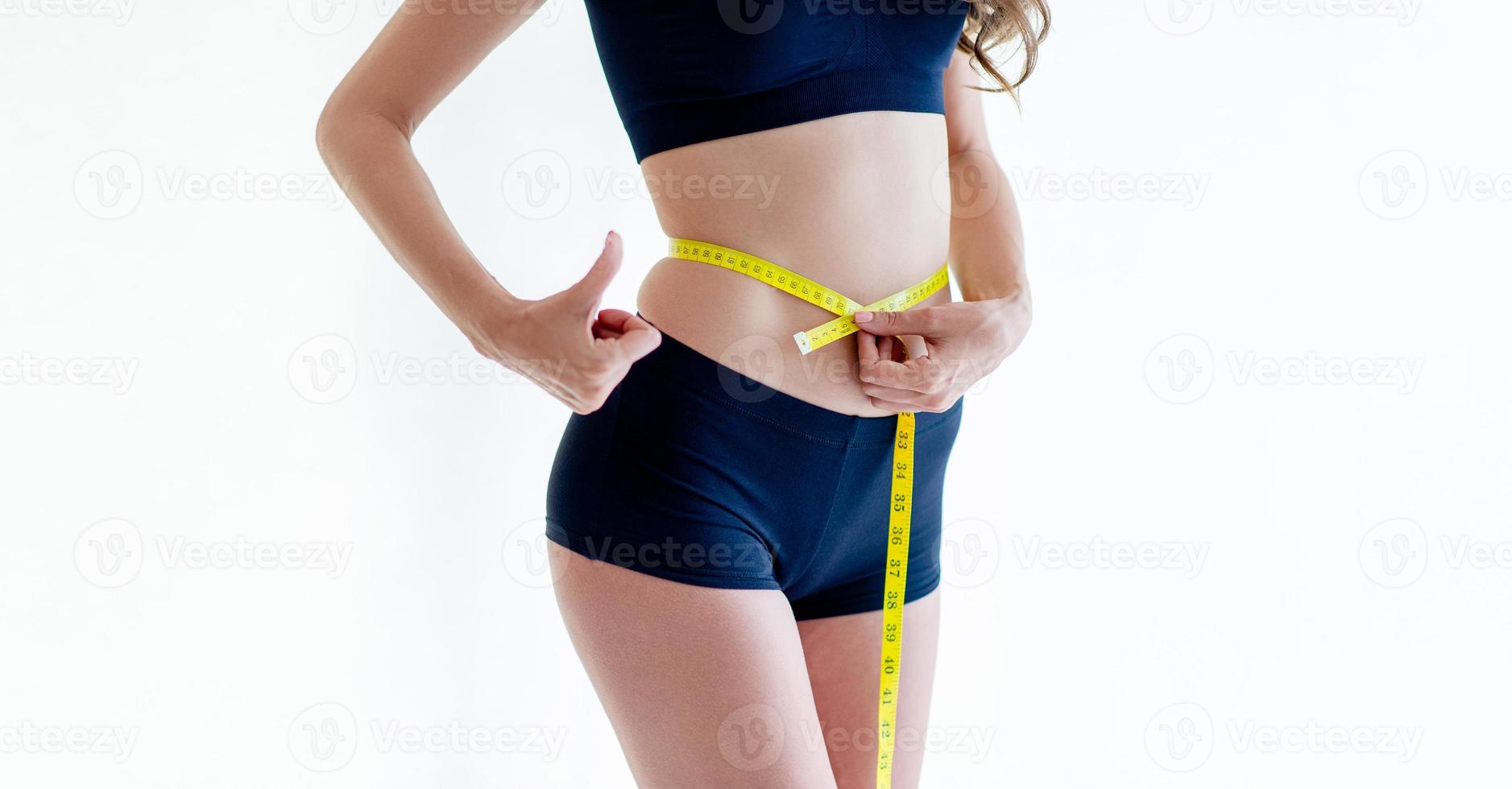 Close-up of a woman in a navy dress Slim figure measured around the waist and torso. Healthy nutrition and weight loss concept. photo