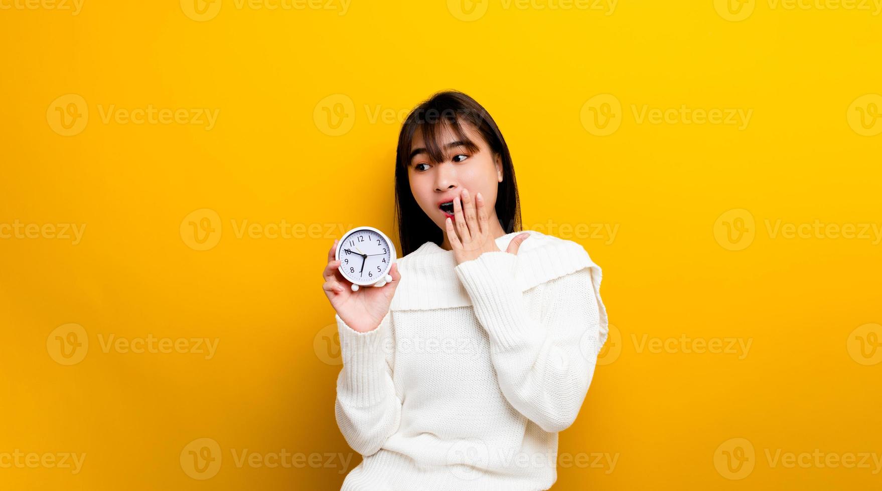 Women and men have time people who are punctual to work woman holding a clock telling the time white planting clock on yellow background photo