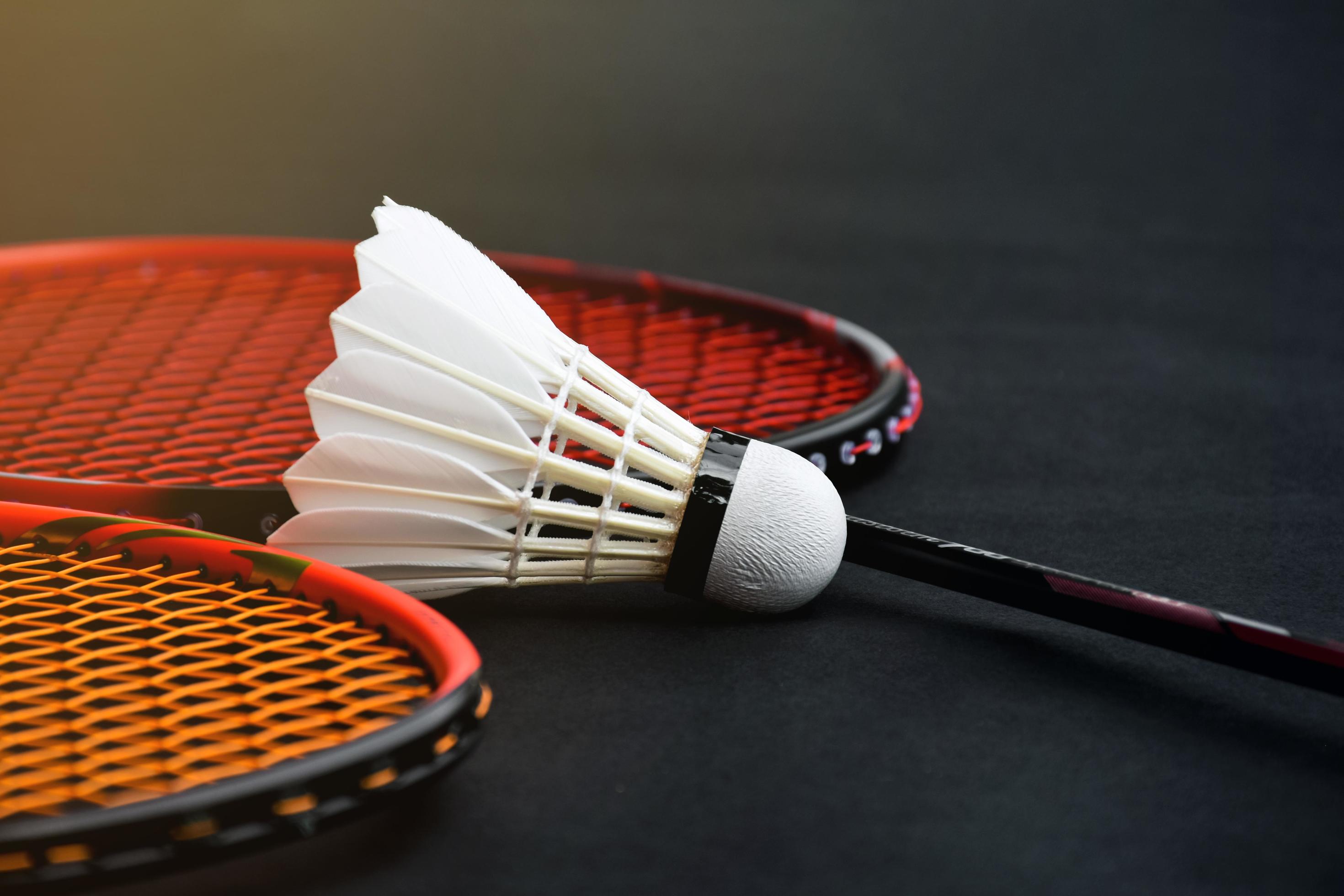 Cream white badminton shuttlecock and racket with neon light shading on  green floor in indoor badminton court, blurred badminton background, copy  space. 6614429 Stock Photo at Vecteezy