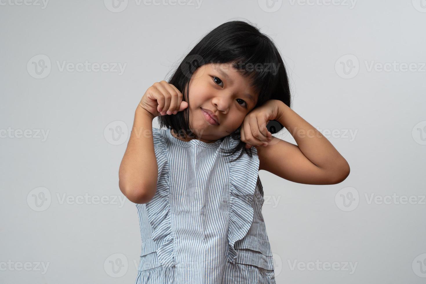 Portrait of happy and funny Asian child girl on white background, a child looking at camera hand gesture. Preschool kid dreaming fill with energy feeling healthy and good concept photo