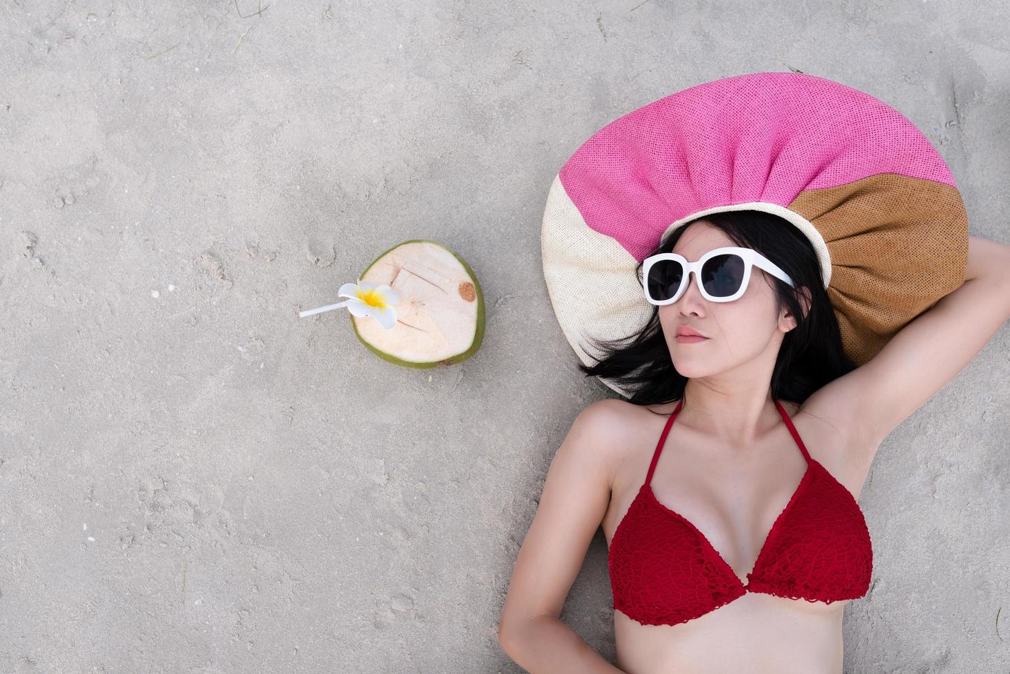 Sexy woman in the red bikini and sunhat on beach photo