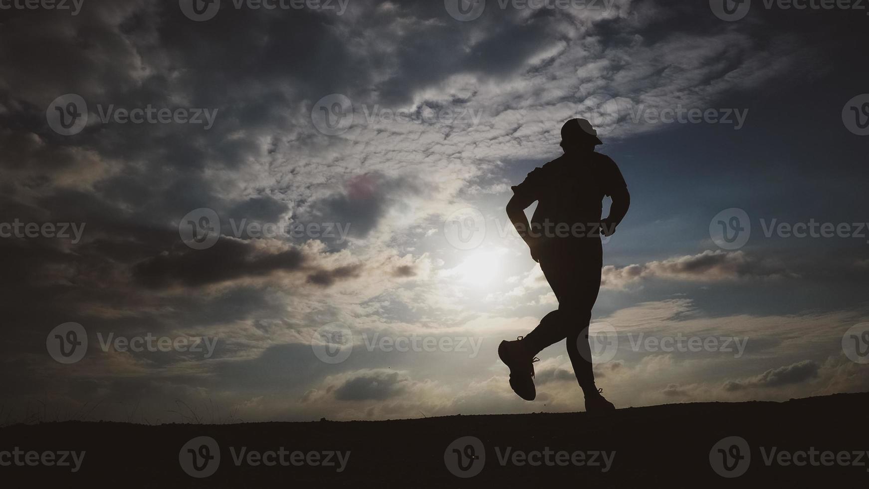 Silhouette Man running in the evening photo