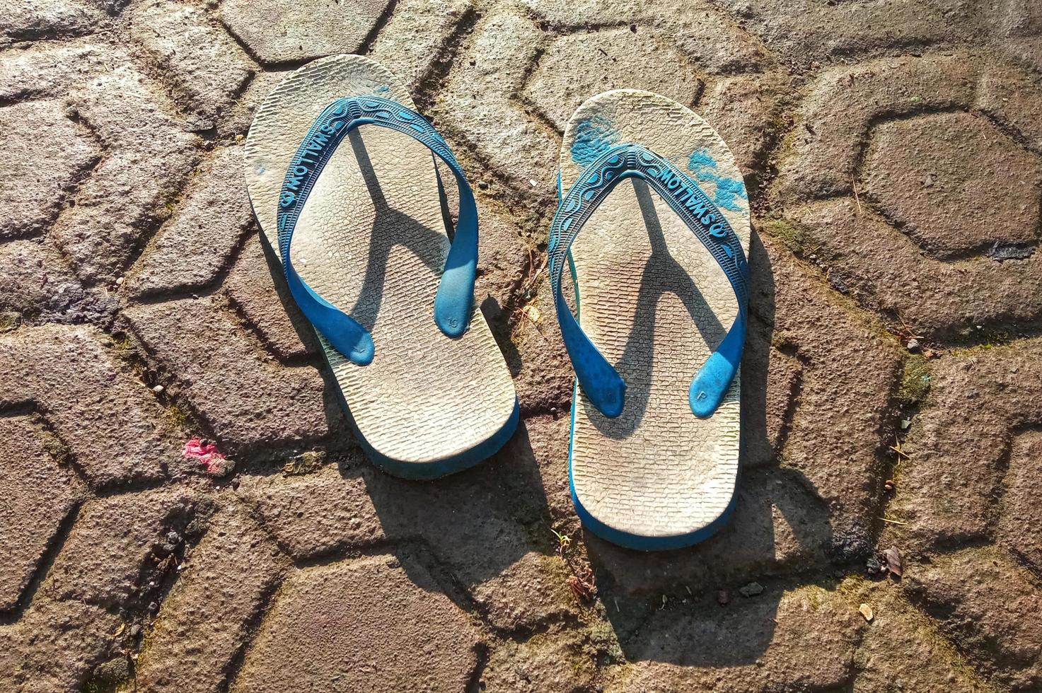 Cianjur Regency, West Java, Indonesia on March 16, 2022 Two pairs of flip-flops in the yard.  Photos to complement the article.