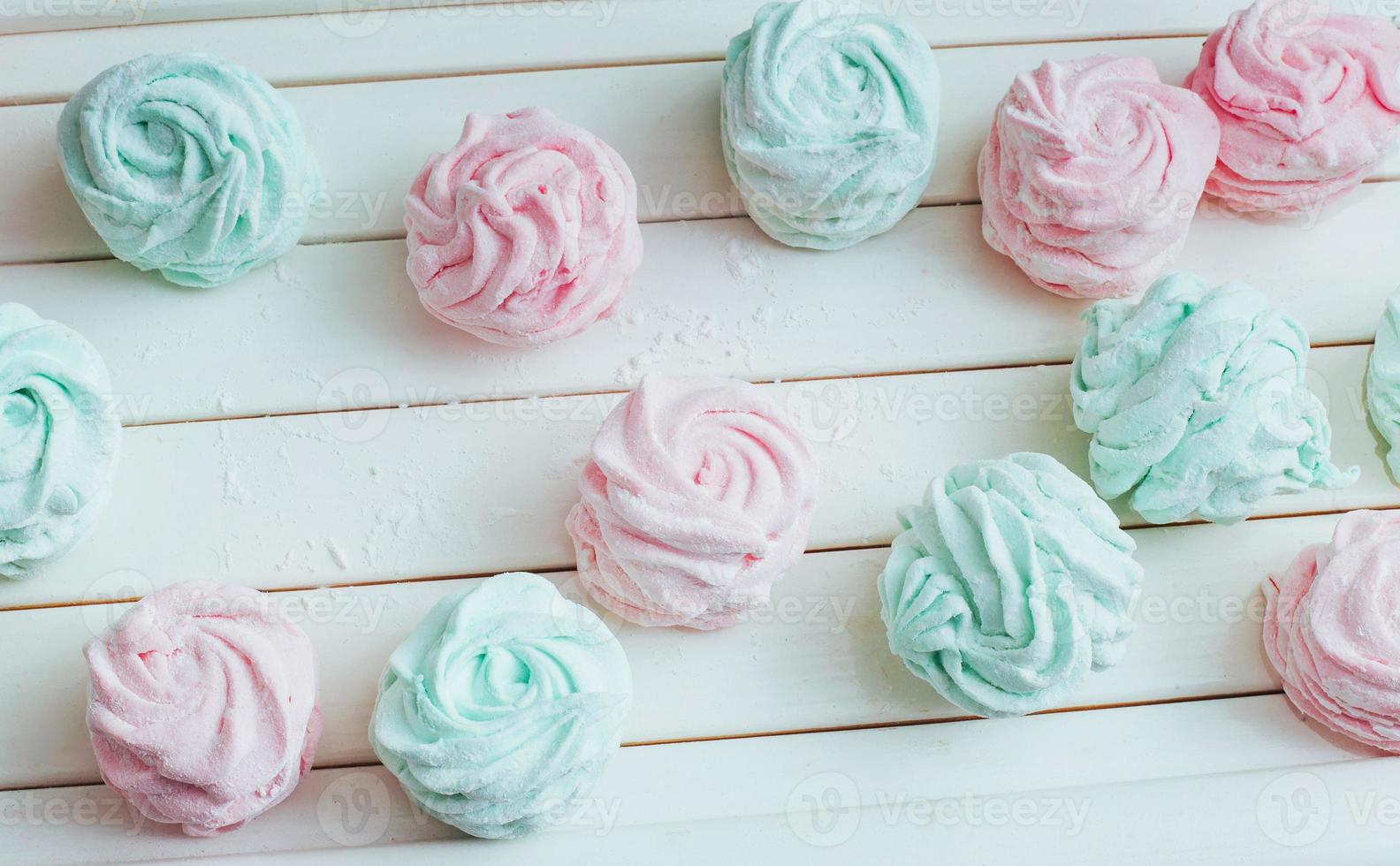 Delicious homemade marshmallow different colors on a white wooden surface. photo