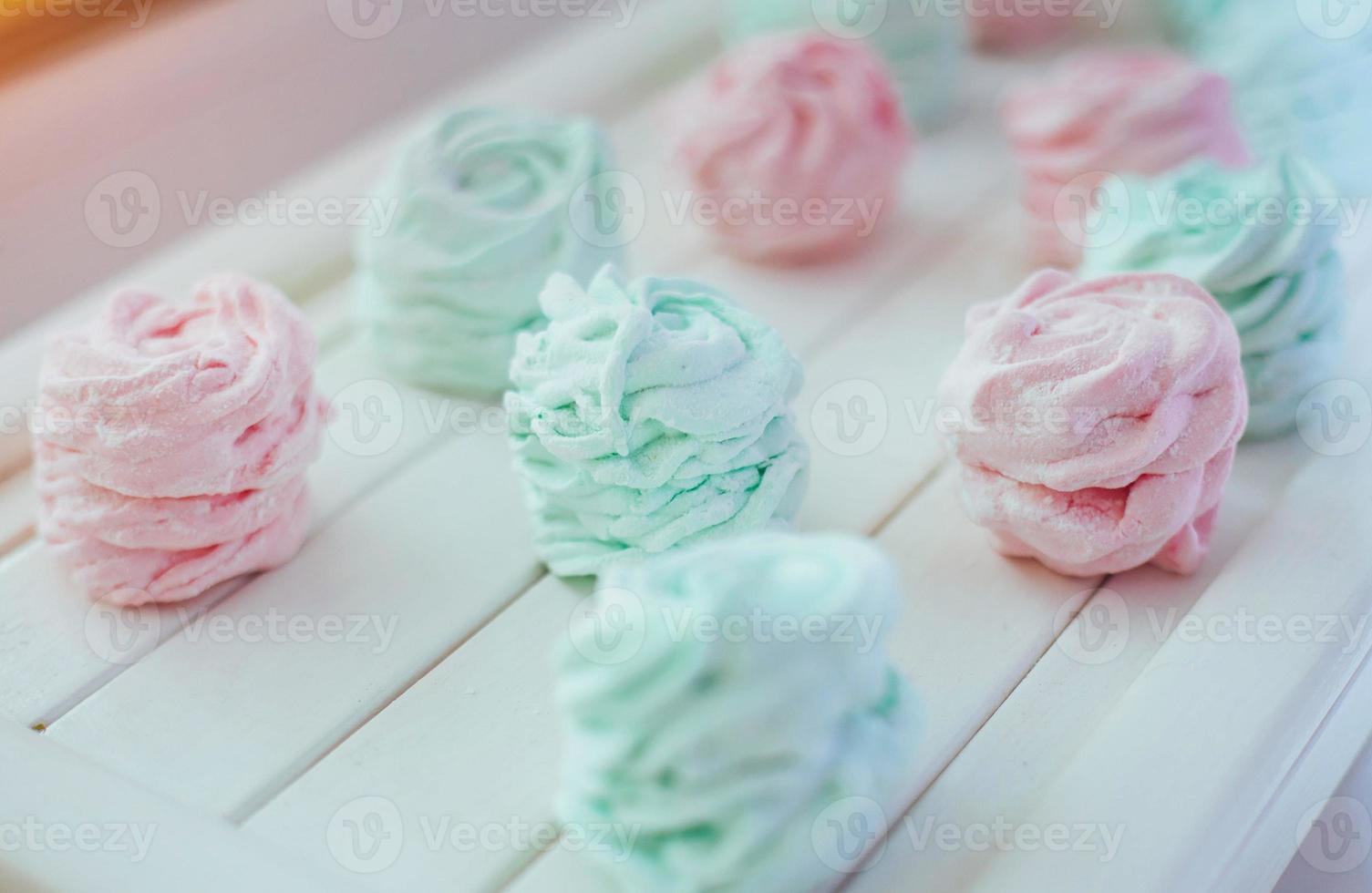 Delicious homemade marshmallow different colors on a white wooden surface. photo