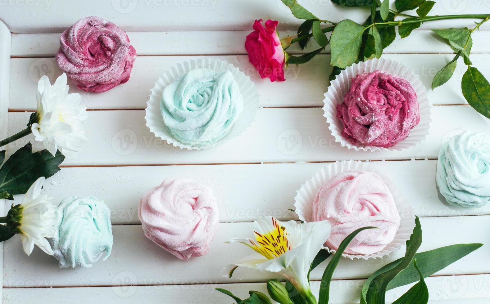 Rose marshmallows and beautiful flowers on a white background wo photo