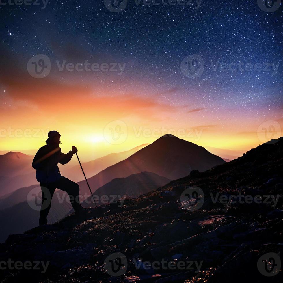 Happy man standing on a cliff. Fantastic starry sky photo