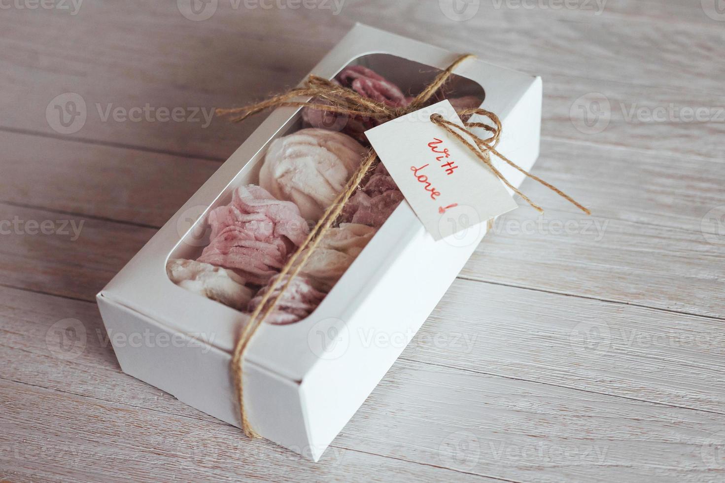 marshmallow in a box on  white wooden background. Delicious swe photo