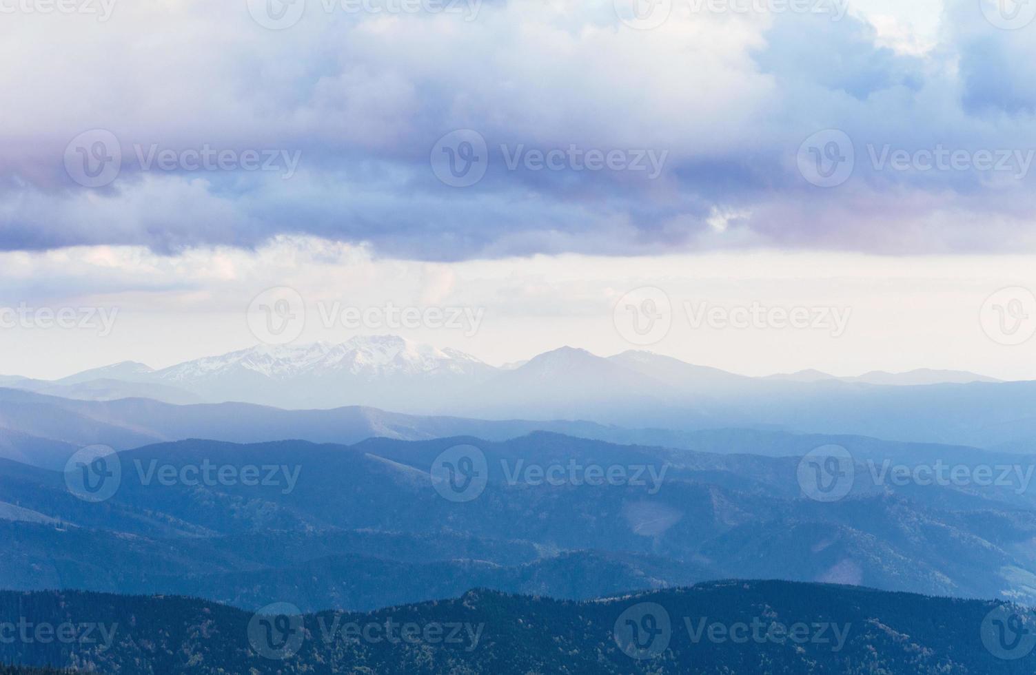 picos de montañas nevadas con niebla en un día soleado. cárpatos, ucrania foto