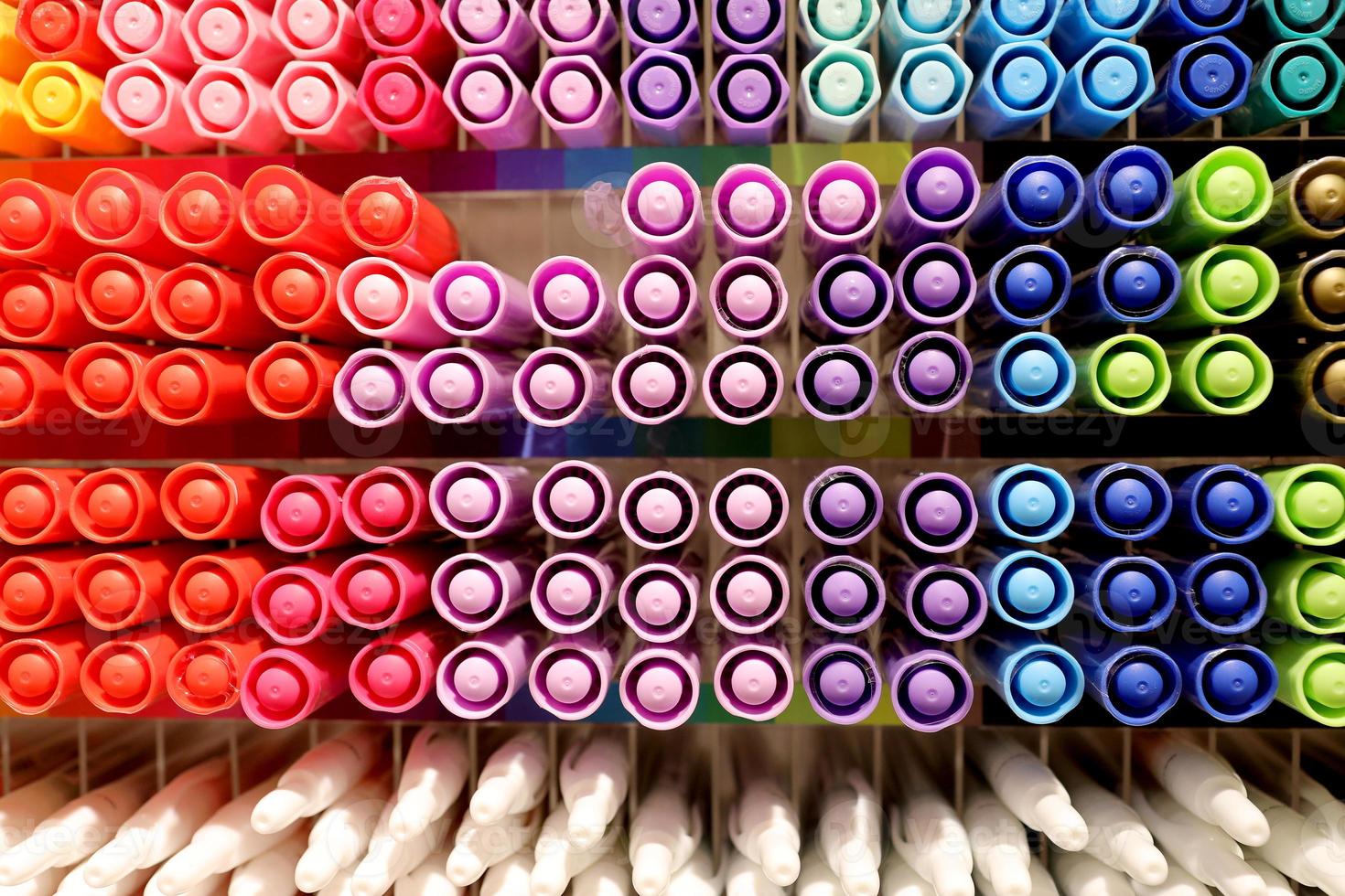 fondo de marcadores de colores en el estante de la papelería. bolígrafos de colores en los estantes de la tienda. bolígrafos de colores dispuestos. foto