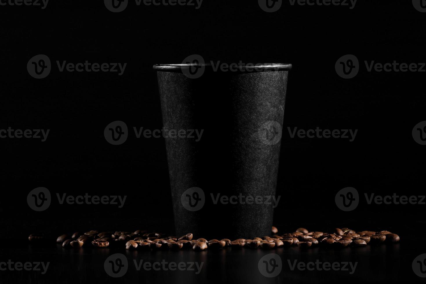 black paper glass on black background. coffee beans on a dark background. good morning photo