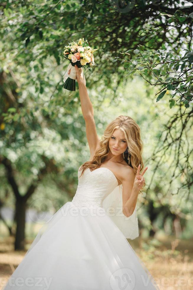 https://static.vecteezy.com/system/resources/previews/006/629/377/non_2x/cute-young-bride-with-long-hairs-holding-her-wedding-bouquet-includes-white-roses-and-other-flowers-beautiful-white-marriage-dress-pretty-girl-on-green-trees-background-photo.jpg