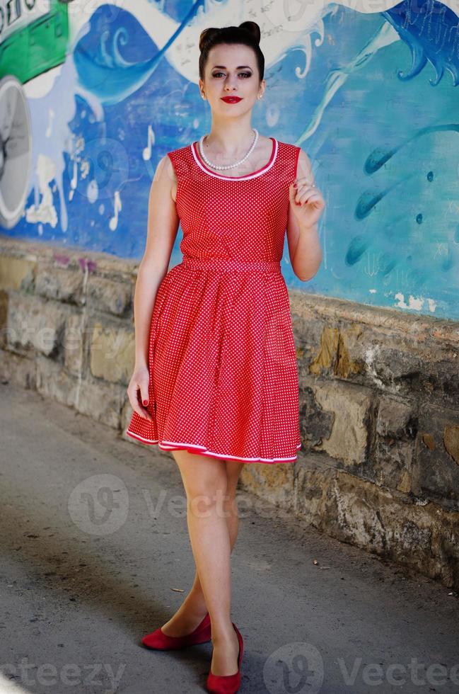 Young pinup girl wearing at retro vintage old-fashioned dress in peas, retro styling. photo