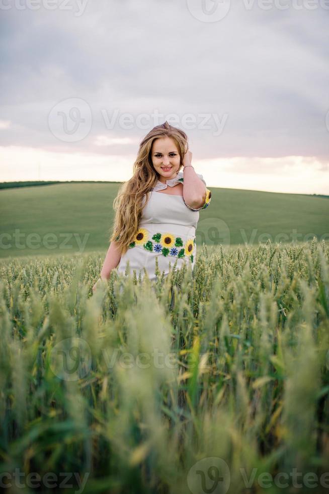 Young girl at ukrainian national dress posed at wreath field. photo