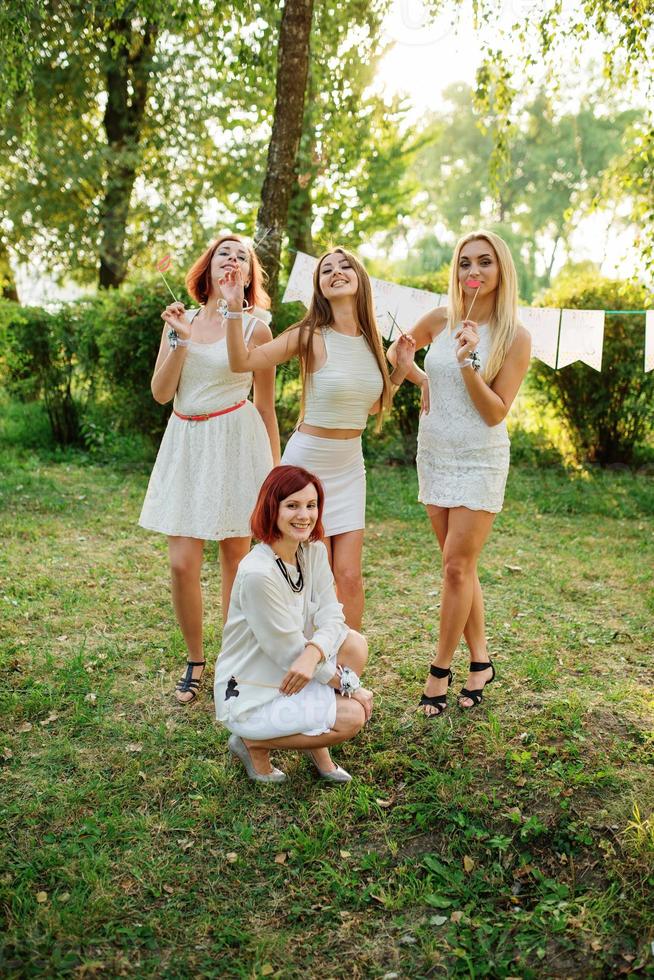 Girls wearing on white dresses having fun on hen party. photo