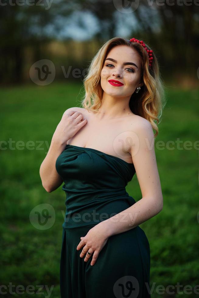 yong elegancia chica rubia en vestido verde en el jardín en primavera. foto