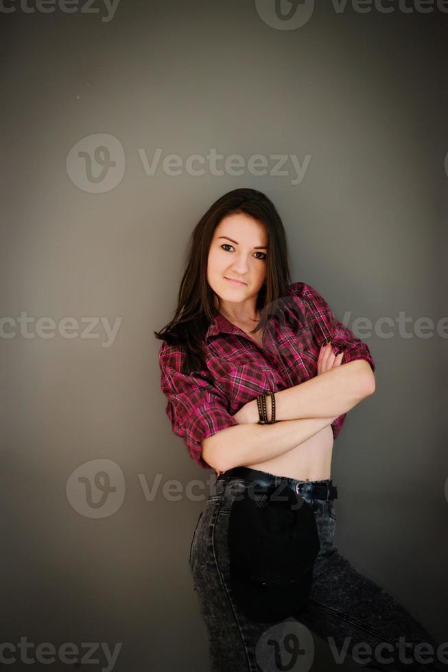 Portrait of brunette girl with cap wearing casual clothes background gray wall. photo