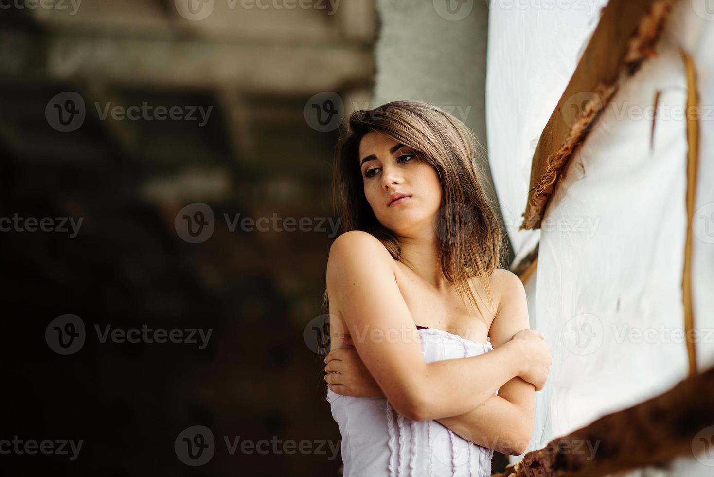 Close up portrait of young cute brunette girl posed on abandoned place. photo