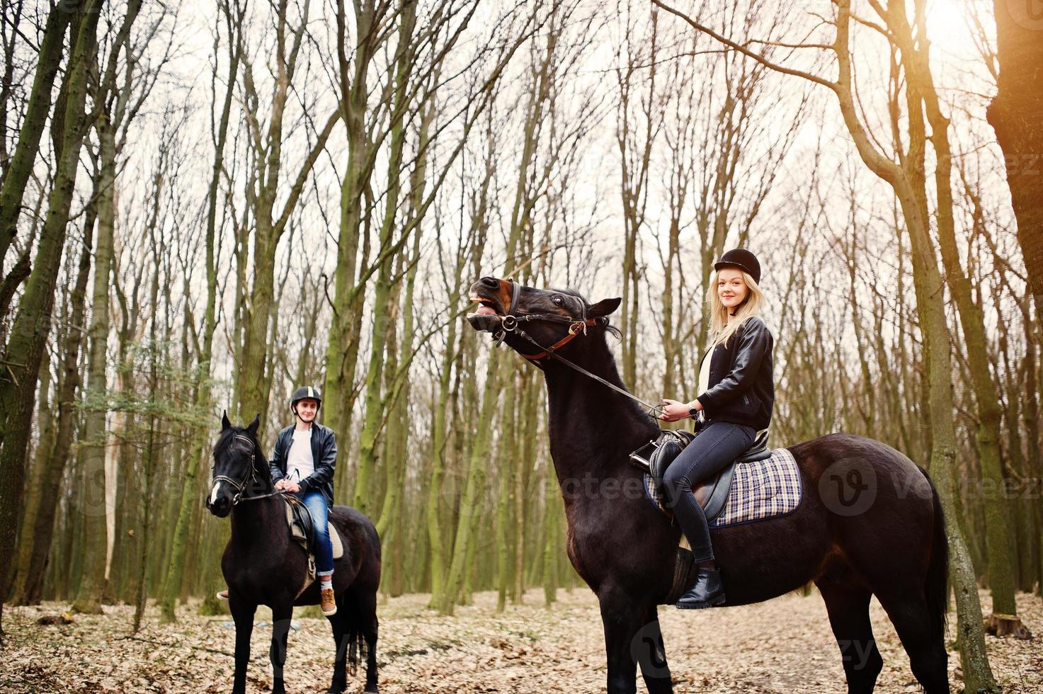 joven pareja con estilo montando a caballo en el bosque de otoño. foto