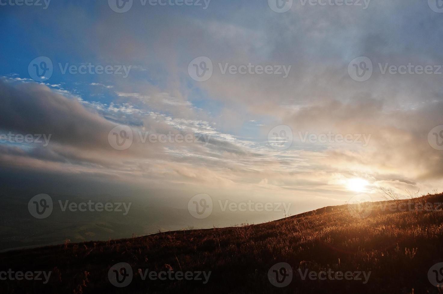 Beautiful sunset and orange sun lights above the mountains. photo