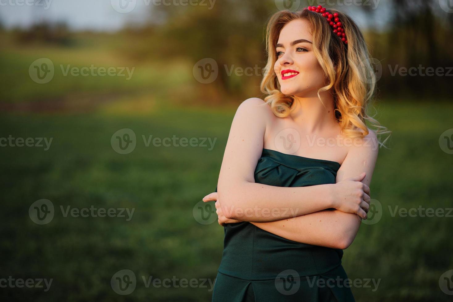 Yong elegance blonde girl at green dress on the garden in spring. photo