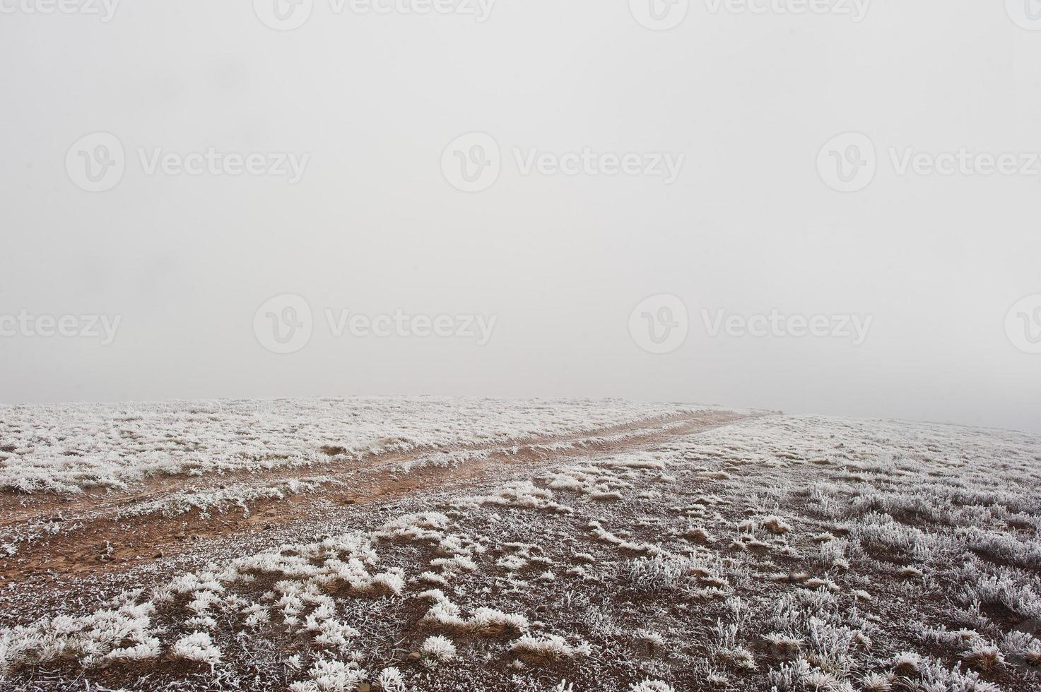 Road to nowhere. Frozen road on foggy mountain photo