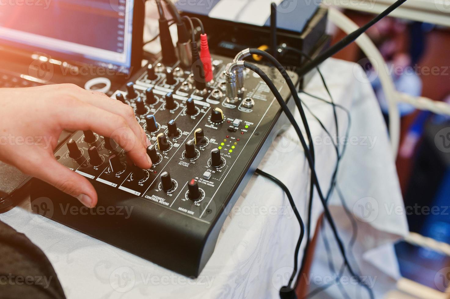 mano del hombre en la mesa de mezclas digital. panel de control del mezclador de sonido, primer plano de los faders de audio. foto