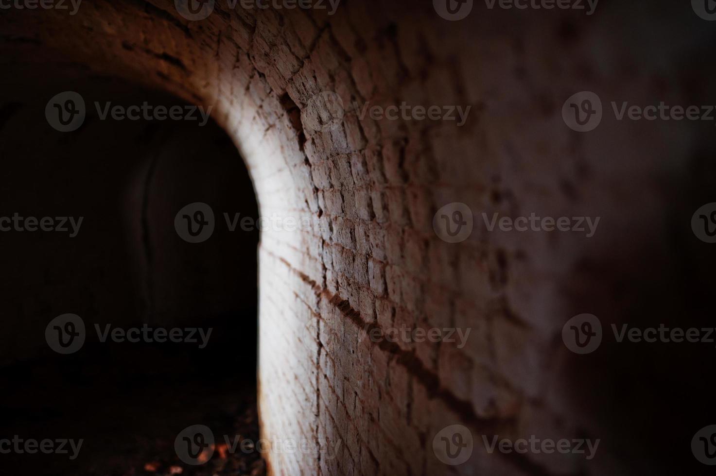 Scary brick arch tunnel on dark and some light. photo