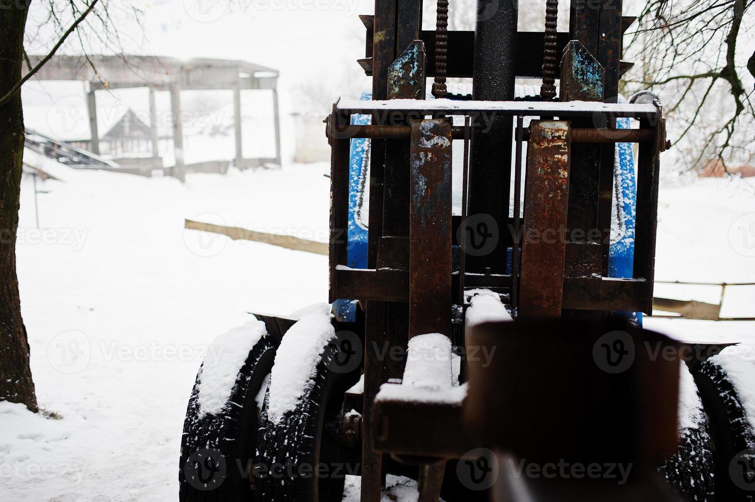 viejo tractor soviético oxidado cubierto de nieve. foto