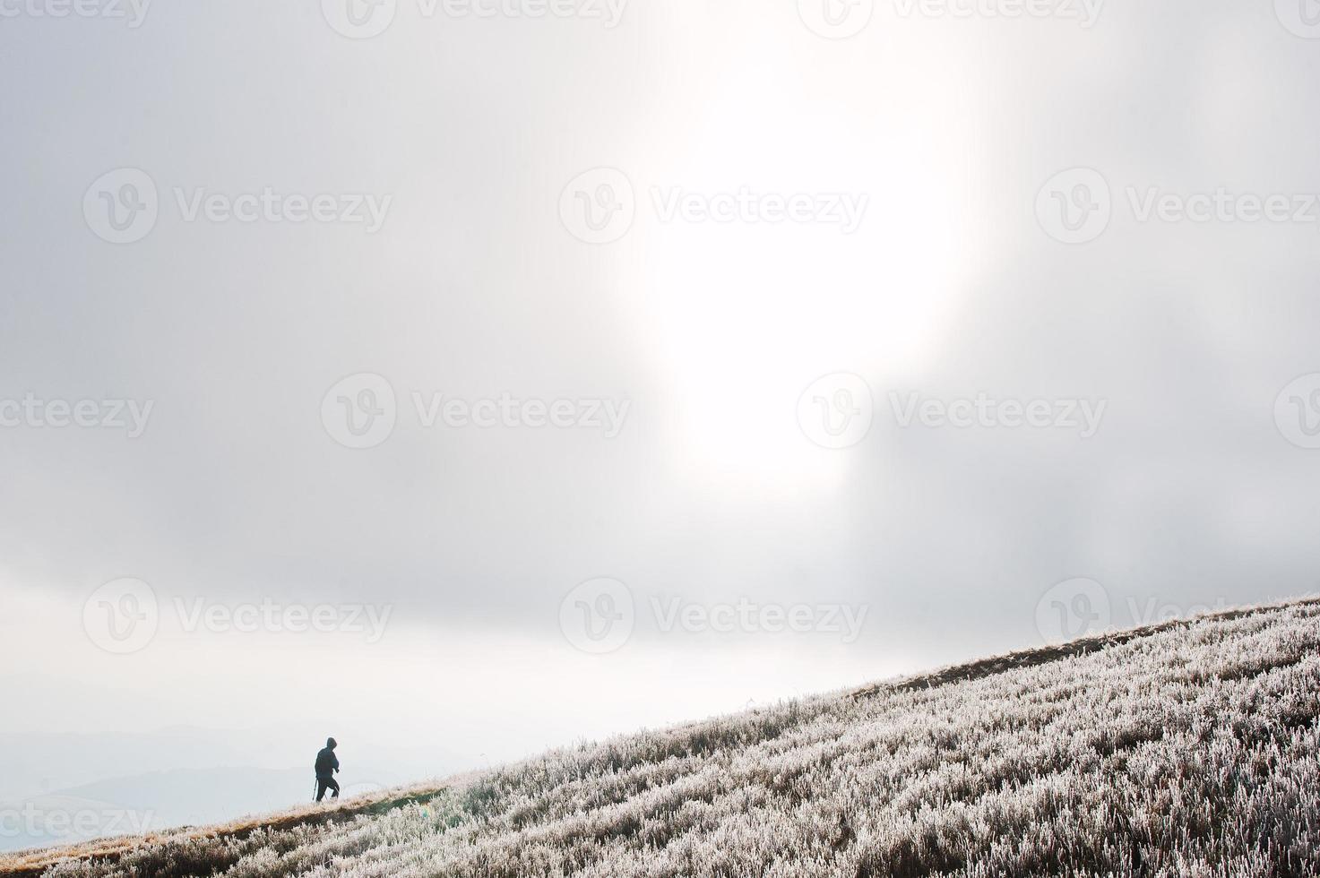 Man rises up at mountain frozen hill. photo