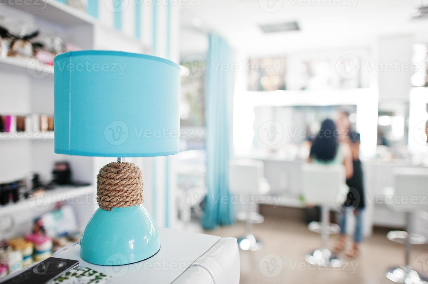 Turquoise desk lamp with decor cord on beauty studio. photo